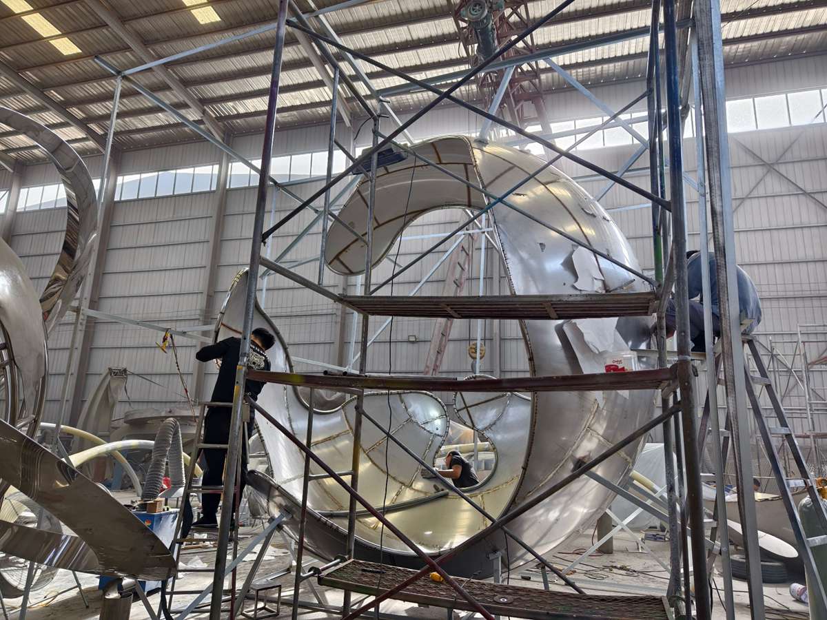 YouFine craftspeople working on a stainless steel sculpture in the factory