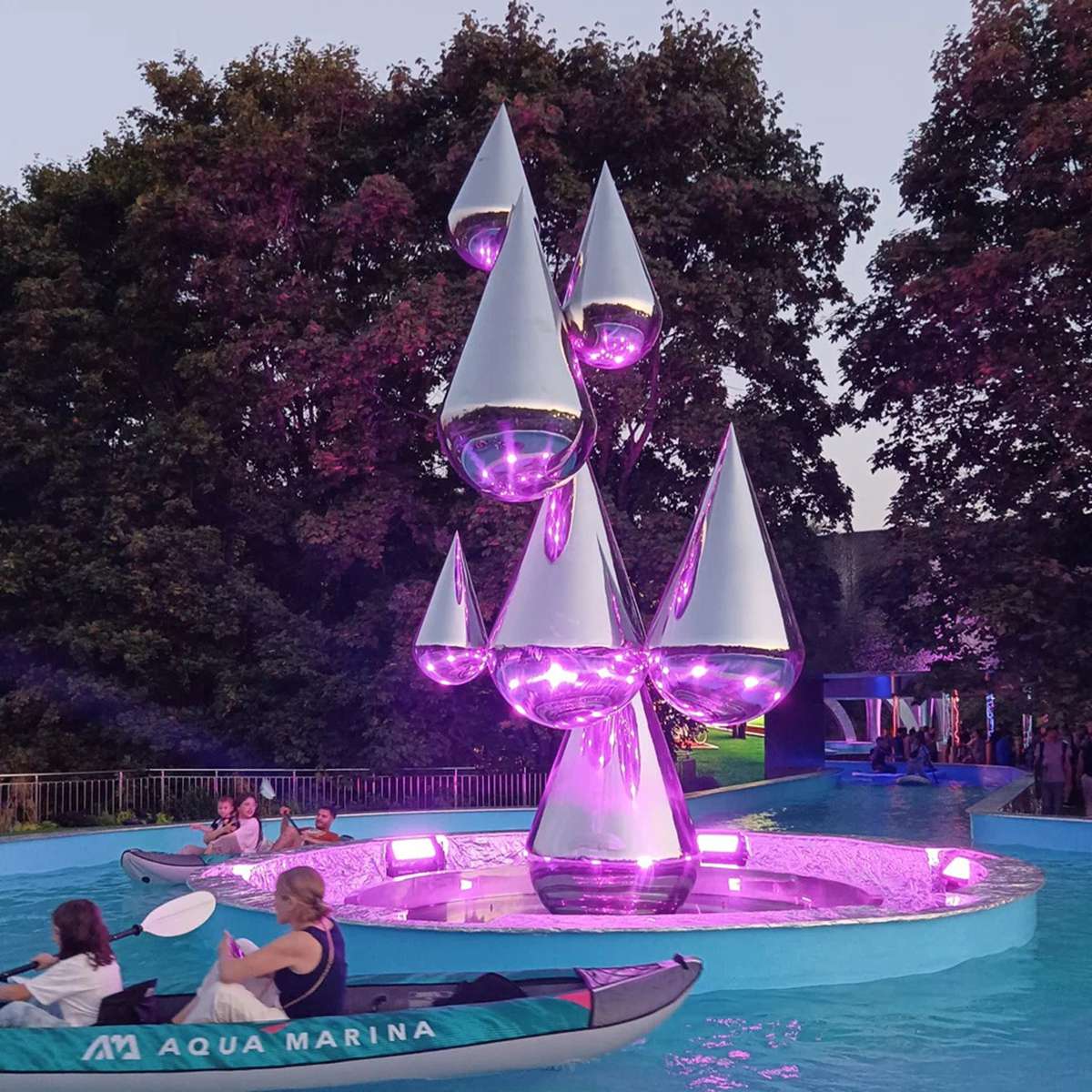 Illuminated stainless steel water feature at night